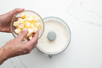 Adding cubed butter to the flour to make the flaky pie pastry
