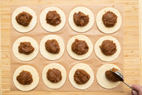 Spooning pumpkin spice filling onto the pastry circles