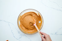 Mixing the spiced pumpkin cake batter with a spatula