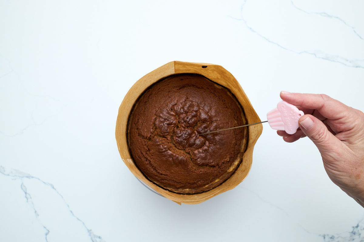 Testing the baked pumpkin cake with a cake tester