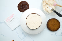 Spreading maple cinnamon frosting between the pumpkin cake layers