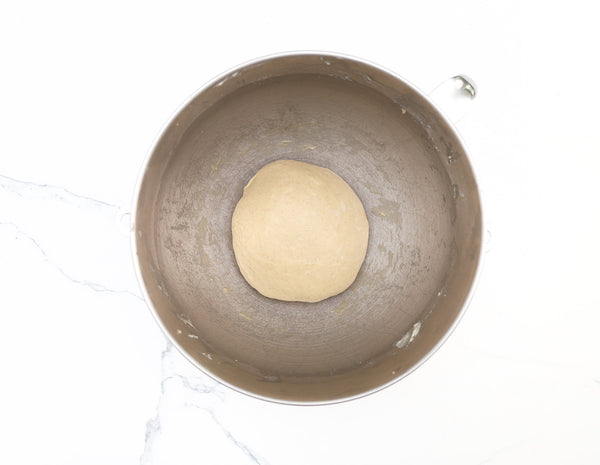 Soft brioche dough ball resting in a mixing bowl