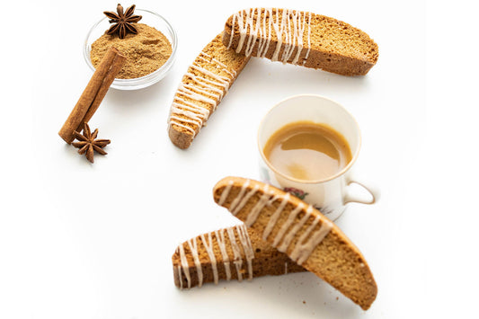 Twice-baked Chai Latte Biscotti with brown-butter chai spice, displayed with a cup of coffee and cinnamon sticks.