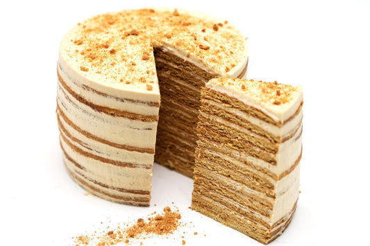 Dulce de Leche & Honey Cake with twelve ultra-thin honey-infused layers and caramelized golden edges, sliced.