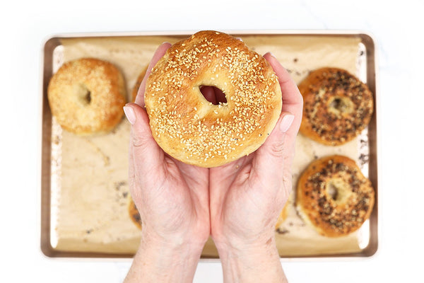 Hands holding a filled pastry over a baking tray during step-by-step home baking process